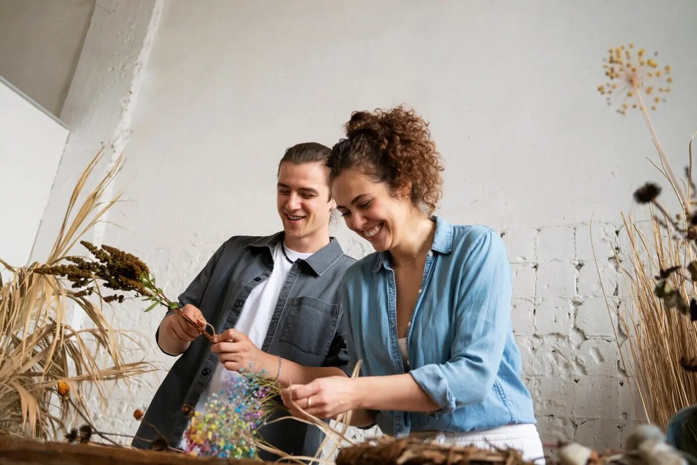 Personen beim Gestalten ihres eigenen getrockneten Arrangements